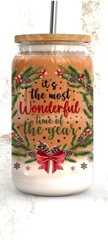Ein 16oz Glasbecher mit Bambusdeckel und Strohhalm, verziert mit dem festlichen Spruch 'It's the most wonderful time of the year', umgeben von Tannenzweigen, roten Beeren, Tannenzapfen und einer roten Schleife. Perfekt für weihnachtliche Getränke.